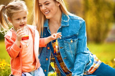 Anne ve kızı parkta portakal suyu içme