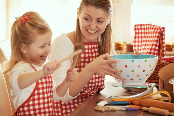 Moeder en dochter meten ingrediënten te maken deeg — Stockfoto