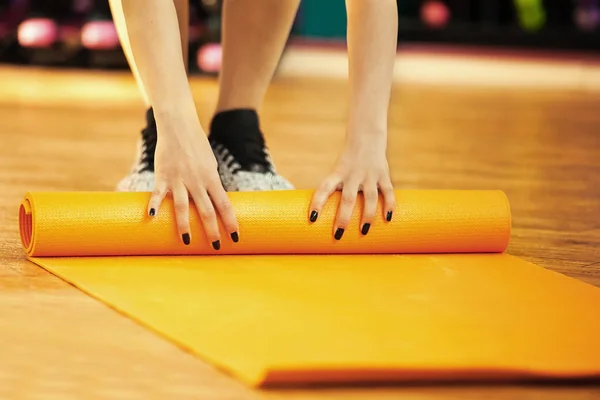 Rollen Yoga matten na klasse. Vrouw in de sportschool. — Stockfoto