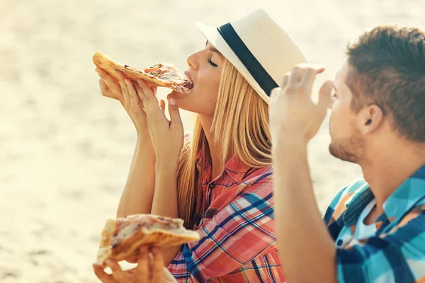 Amor casal comer pizza e beber cerveja na praia — Fotografia de Stock