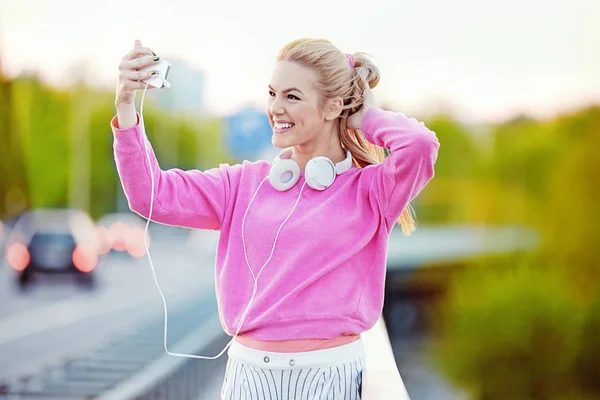 Hermosa mujer joven que se relaja con el teléfono celular después de correr — Foto de Stock