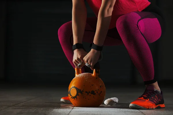 Jonge past vrouw door kettlebell training. — Stockfoto