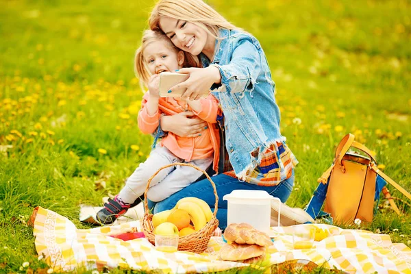 Mamá y su hija disfrutando de un picnic en el parque — Foto de Stock