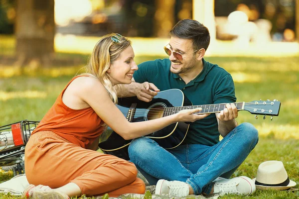 Amor casal que gosta de guitarra no parque — Fotografia de Stock