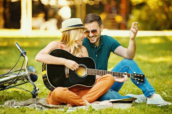 Amor casal que gosta de guitarra no parque — Fotografia de Stock