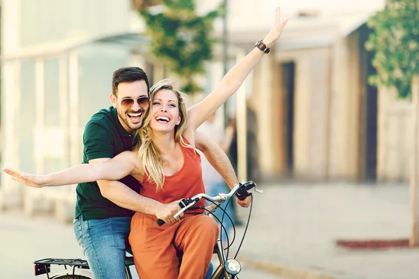 Pareja feliz montando una bicicleta — Foto de Stock