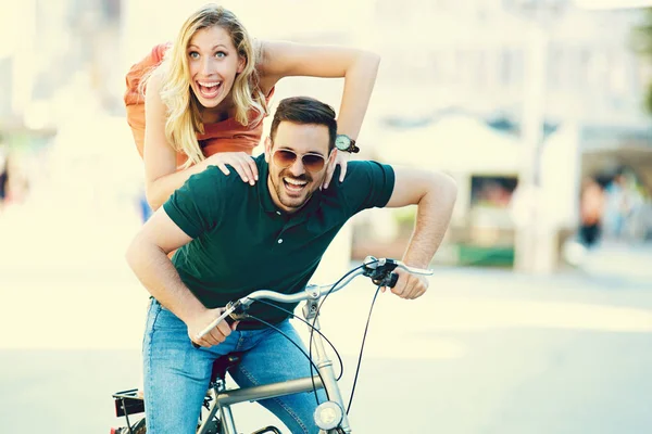 Pareja feliz montando una bicicleta — Foto de Stock