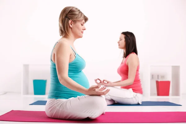 Těhotná žena praktikující jógu — Stock fotografie
