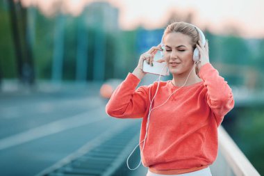 Güzel genç kadın egzersiz sonra cep telefonu kullanarak