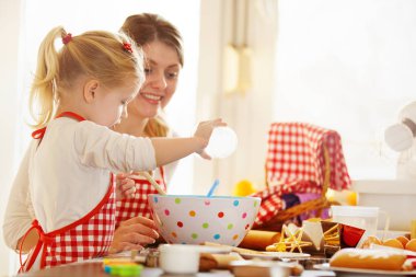 Mutfakta mutlu bir aile. Anne ve kızı destek kek.