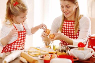 Mutfakta mutlu bir aile. Anne ve kızı yumurta hazırlanıyor 
