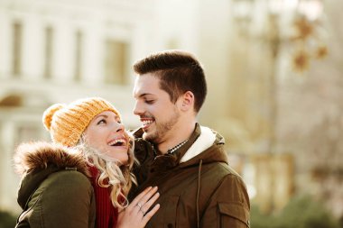 Gülümseyen çift birbirlerine bir sonbahar günü sarılma.  