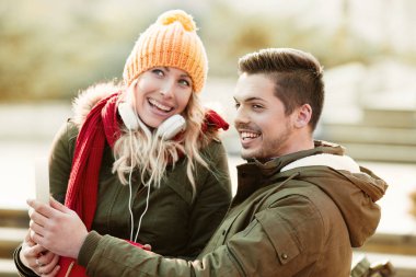 Gülümseyen çift birbirlerine bir sonbahar günü sarılma.  