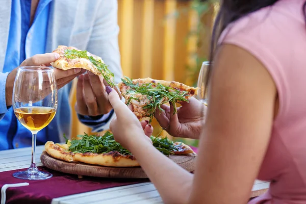 Ferme là. Les mains de couple prenant une tranche de pizza . — Photo
