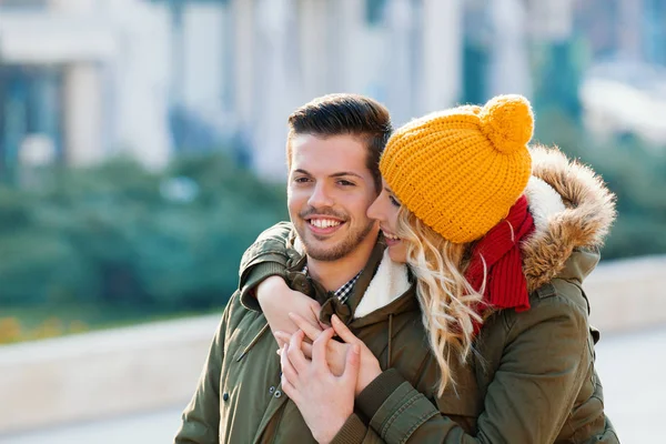 Gülümseyen çift birbirlerine bir sonbahar günü sarılma.  