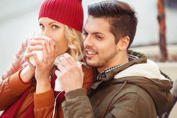 Casal sorridente tendo bebida quente ao ar livre em um dia de outono . — Fotografia de Stock