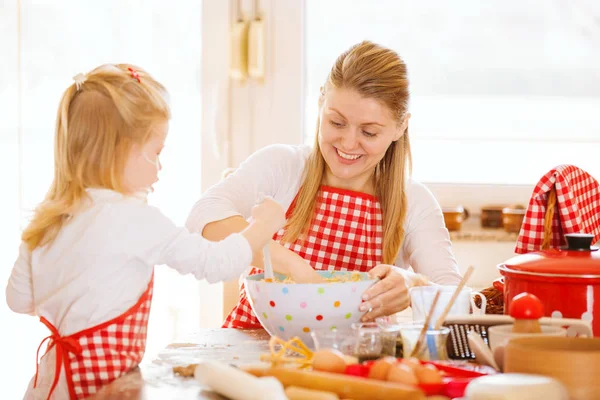 Mutfakta mutlu bir aile. Anne ve kızı destek kek.