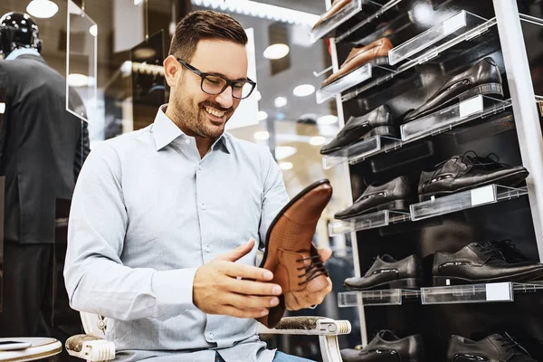 Genç adam ayakkabı alış gülümseyen