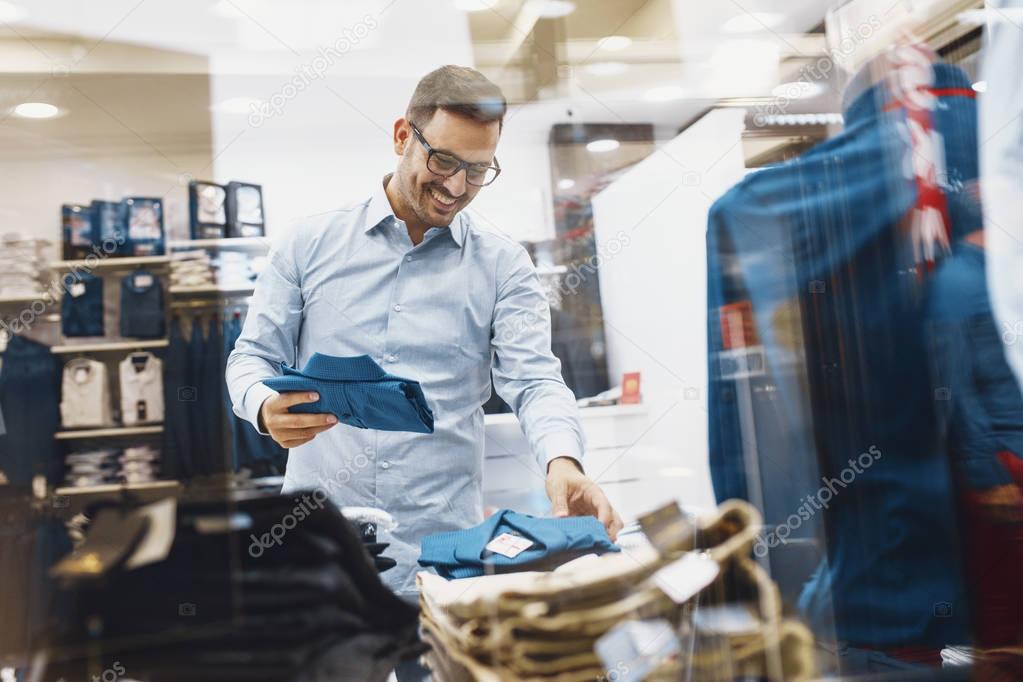 Smiling Young Man Buying a Shirt