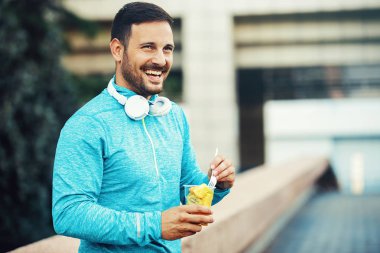 Adam sabah egzersiz yaptıktan sonra meyve yiyor