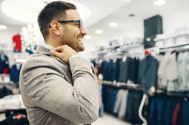 Gülümseyen genç adam bir gömlek satın