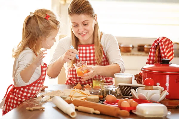 Moeder en dochter meten ingrediënten te maken deeg — Stockfoto