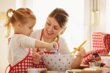 Mutfakta mutlu bir aile. Anne ve kızı destek kek.