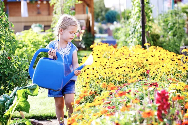 Criança está regando flores — Fotografia de Stock