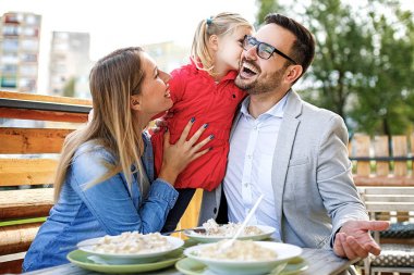 Mutlu bir aile restoranı makarna keyif alıyor.