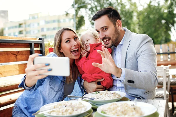 Happy family is enjoying pasta in restaurant.