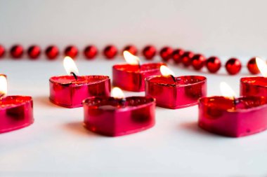 Beyaz arka planda kalp şeklinde bir mum aşkın sembolüdür.