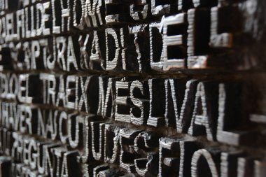 Spain, Catalonia, Barcelona, Sagrada Familia, Antonio Gaudi. Metal exit doors. Bronze letters. Latin text on a black background. Embossed letters. 