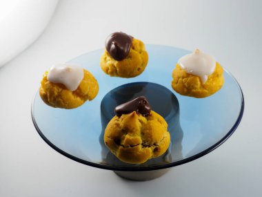 Kremalı ve çikolatalı dört Profiterol.