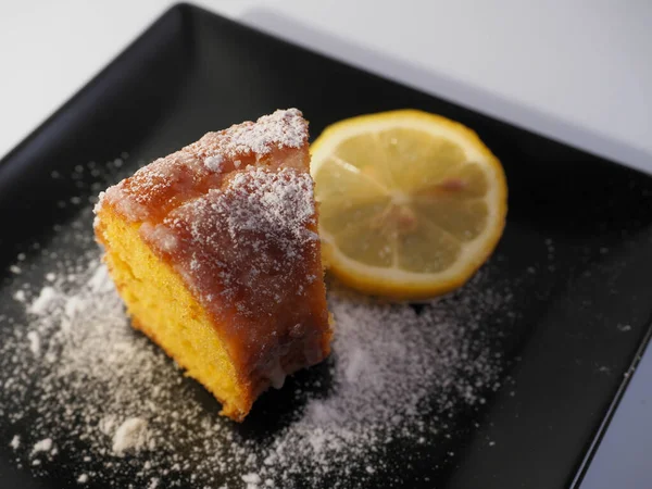 Hausgemacht Aus Süßem Zitronenkuchen Auf Einem Schwarzen Teller Mit Puderzucker — Stockfoto