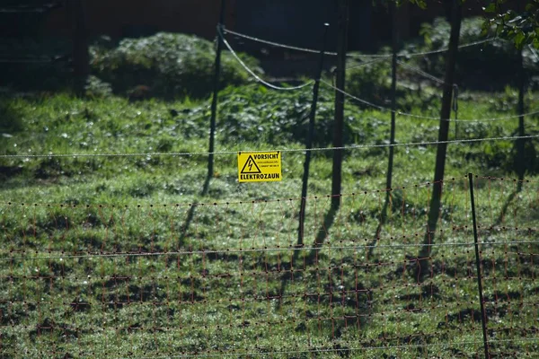 Предупреждающий знак опасности на электрическом заборе — стоковое фото