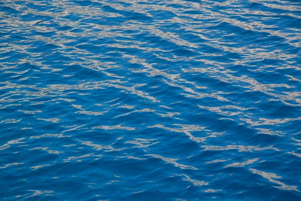 Textura de agua azul con algunos reflejos naranjas . —  Fotos de Stock