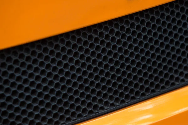 Detalhe da grade do carro no esporte de luxo laranja e carro preto . — Fotografia de Stock