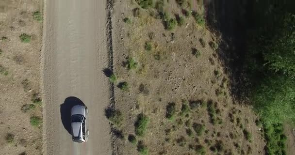 Cena aérea do drone, vista superior da estrada do cascalho na paisagem da estepe. Sandy, zona seca. A carrinha e o carro passam pela estrada. Patagônia, Argentina . — Vídeo de Stock