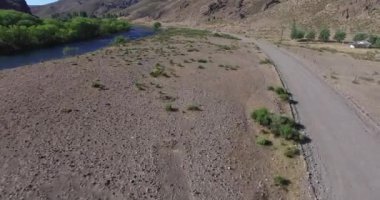 Çakıl yol ileri hareketli van izleme bozkır içinde hava dron sahne. Arka planda dağlar. Sinek Balıkçılık nehir Patagonya Arjantin ile kırsal manzara çöl.