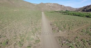 Çakıl yol Bozkır ve ileri hareketli van hava dron sahne. Arka planda dağlar. Statik kamera hareketi. Patagonya Arjantin kırsal manzara çöl.