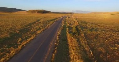 Patagonia, Arjantin için günbatımı hava dron sahne. Bozkır manzara. Çok hızlı ilerlemeye ve kamera yukarıdan yolun aşağı kaydırma yaparken yakın bir araba almak fotoğraf makinesi.