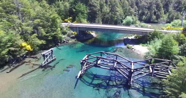 Drone aérien encore scène de vieux pont en bois brisé et autoroute au-dessus de la rivière transparente, turquoise, cristalline, affluent de ruca malen du lac Correntoso, Patagonie, Argentine. Voitures passent par la route — Video