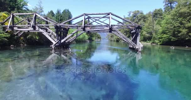 Drone scène van oude houten brug over blauw transparant Patagonië rivier. Ruca Malen. In de buurt van de rivier stroom door door de brug. Argentinië. Ruta 40. — Stockvideo