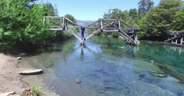 Drone scène van oude houten brug over blauw transparant Patagonië rivier. Ruca Malen. Camera beweegt pannen van de brug structuur. Argentinië. Ruta 40. — Stockvideo