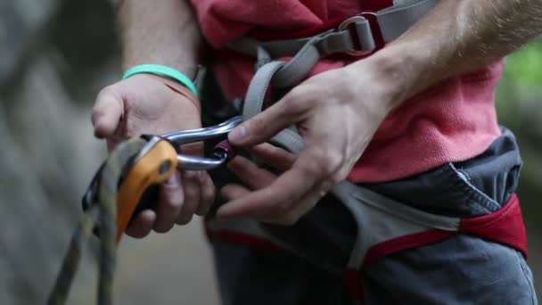 Rock climbing detail of climber harness. Man locking carabiner and catching the rope with rustic hands about to belay. Slow motion 120 fps detail close up scene. Risk outdoor sport. Patagonia. — Stock Video