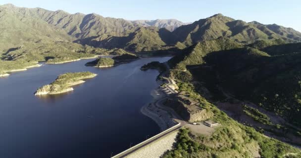 Aerial drone scene of panoramic view of dam with its lake. Flying following road surrounding lake. Background of mountains. Nogoli, San Luis, Argentina — Stock Video