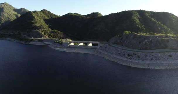 Letecká letecká scéna přehrady a jejího jezera, letící směrem k přetékající stavbě. Od panoramatického až po senilní pohled. Nogoli, San Luis, Argentina. — Stock video