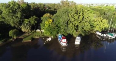 Aerial drone scene showing tranquil river delta moorings. Descending showing detail of fisherboat. Gualeguaychu, Entre Rios, Argentina
