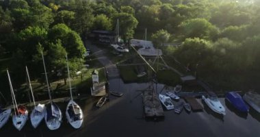 Denizciye doğru uçan hava aracı sahnesi, tamir edilen yelkenli. Kıyıya demirlemiş tekne ve yatlar. Unzue Parkı, Gualeguaychu, Entre Rios, Arjantin