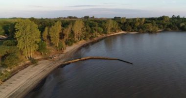 Gün batımında doğal manzarada sahilin hava aracı görüntüsü. Uruguay nehrinin kum ve orman kıyısında uçuyor. Las Caas, Rio zenci bölgesi, Uruguay